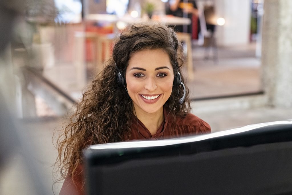 Woman customer operator with headset working on computer. Portra